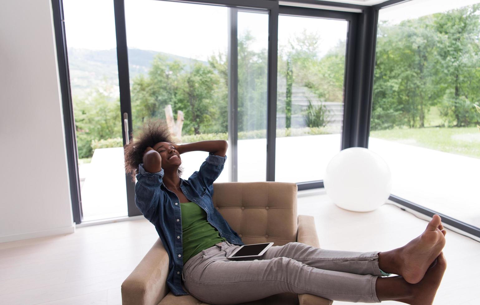 africano americano donna a casa con digitale tavoletta foto