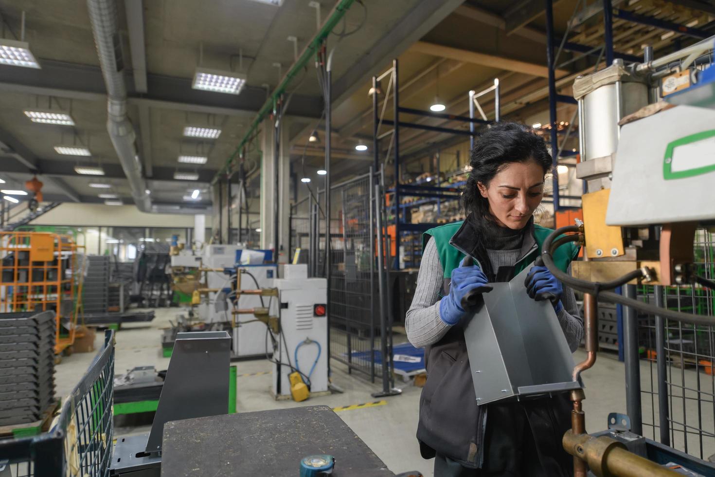 tacchino, 2022 - un' donna Lavorando nel un' moderno metallo fabbrica assembla parti per un' nuovo macchina foto