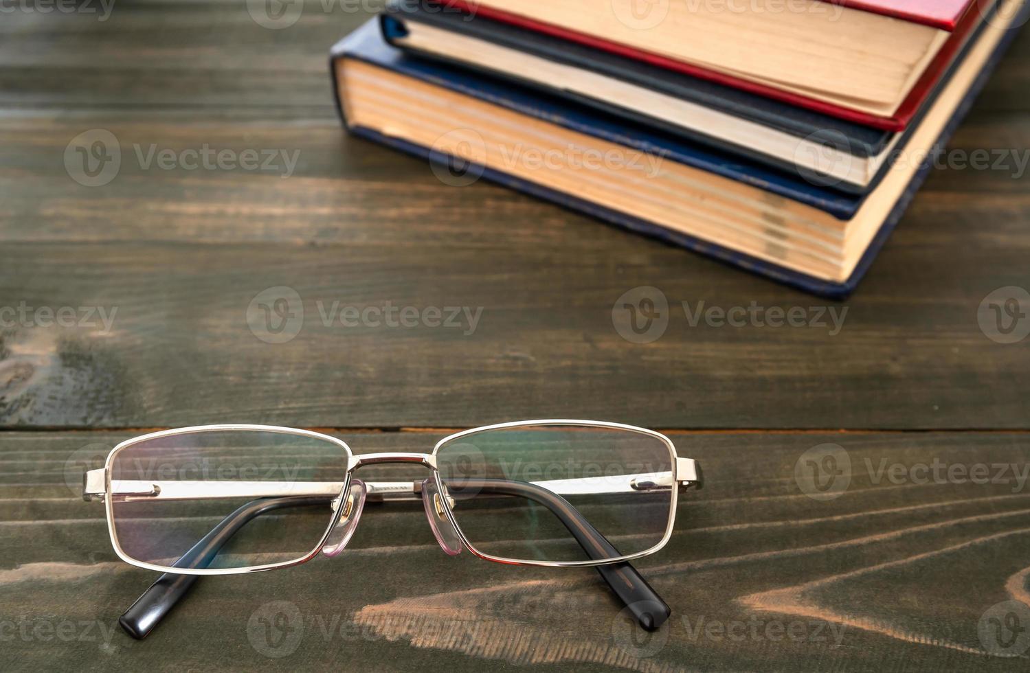 bicchieri e pila di libri con copertina rigida foto