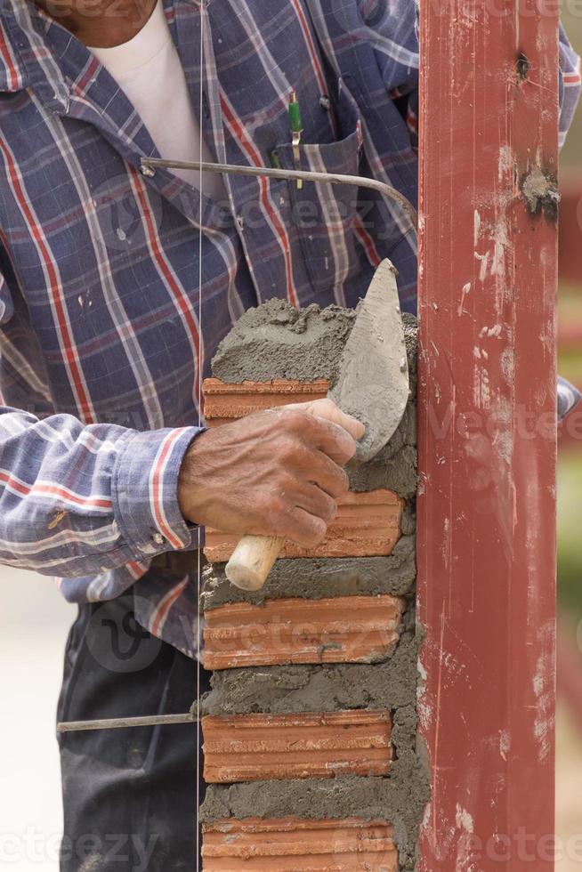 muratore Lavorando nel costruzione luogo di mattone parete foto