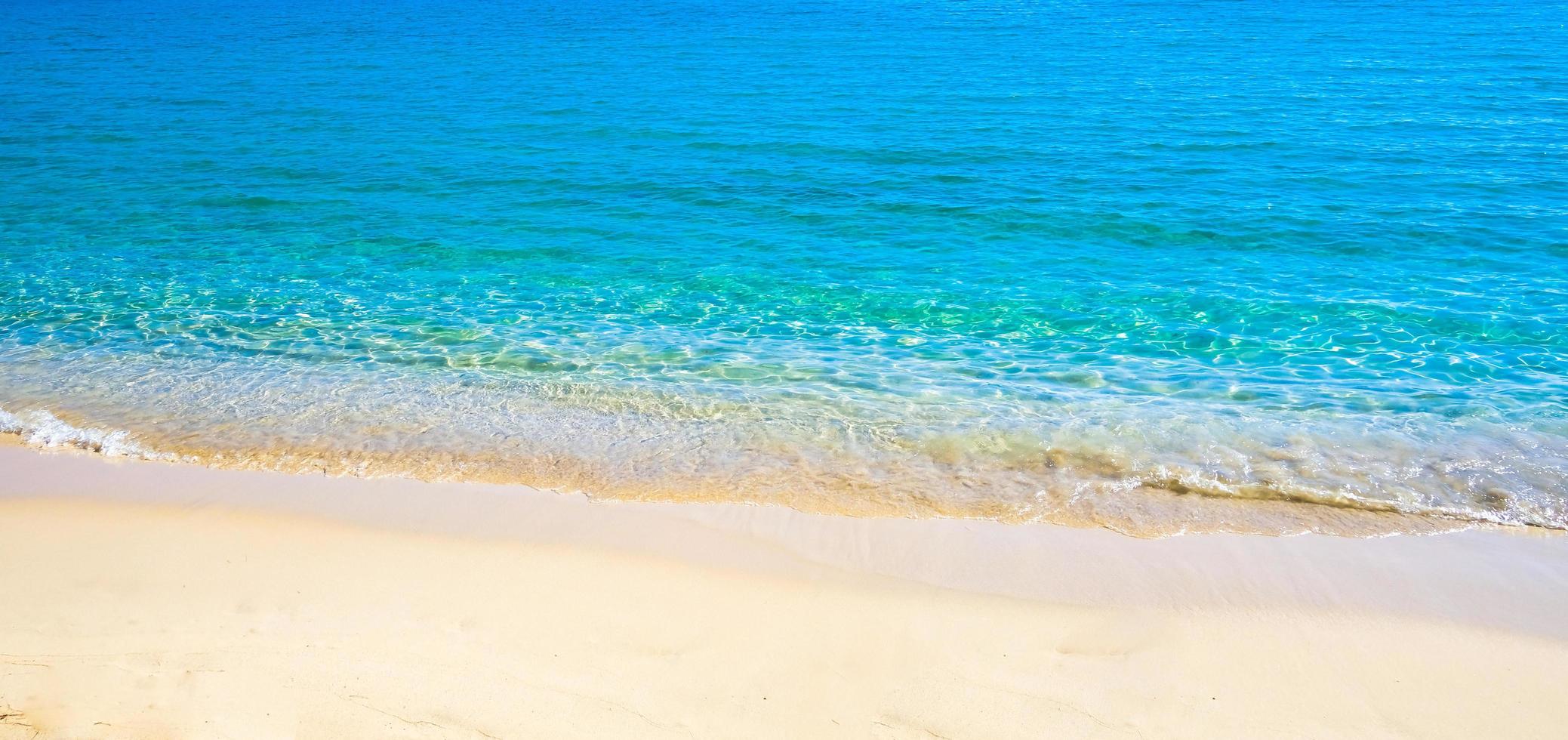 blu mare superficie con onde struttura su spiaggia sfondo foto