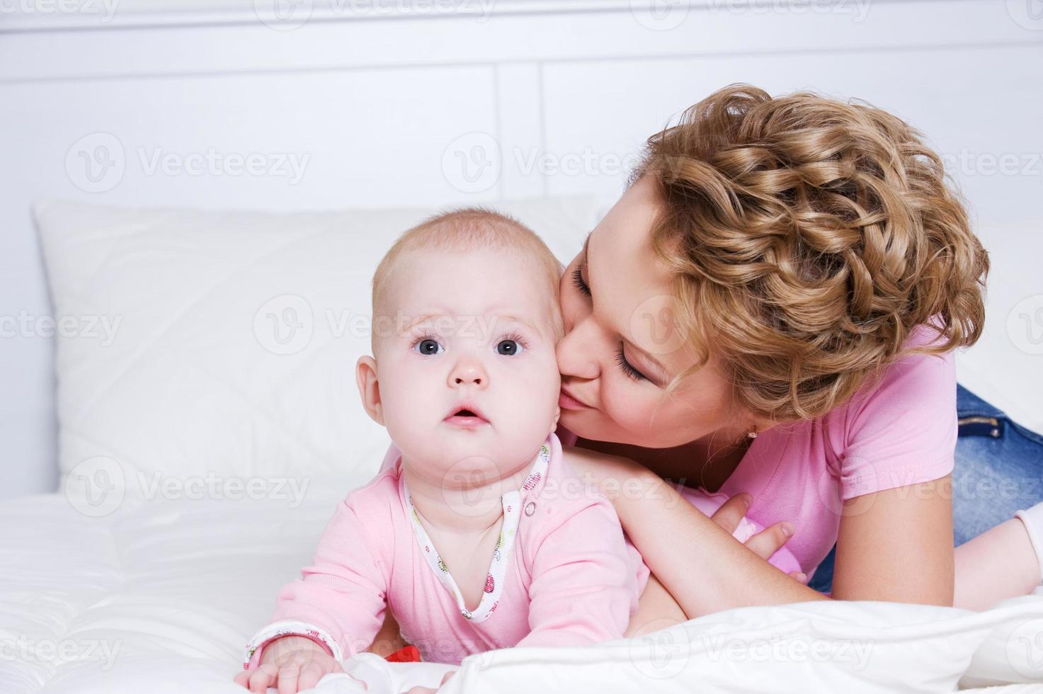 bella mamma che bacia bambino attraente foto