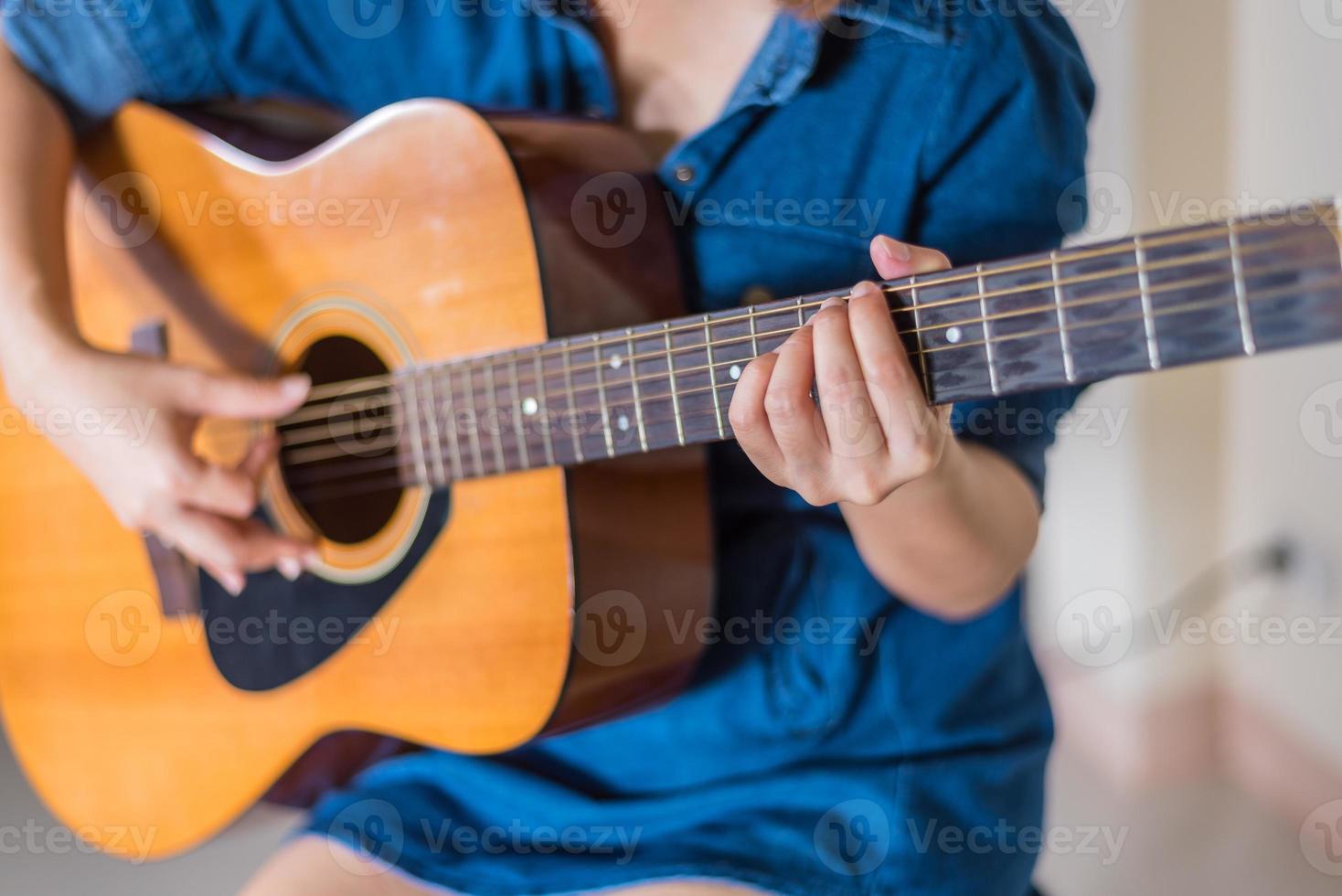 ragazza che gioca l'isolato della chitarra acustica su bianco foto