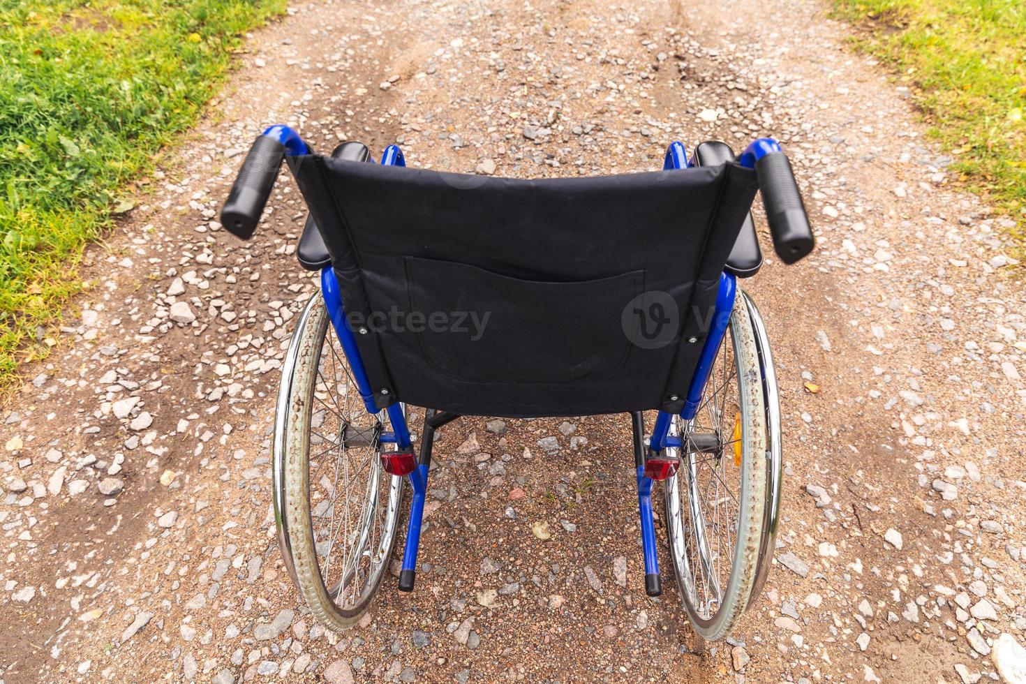 sedia a rotelle vuota in piedi sulla strada in attesa di servizi per i pazienti. sedia a rotelle per persone con disabilità parcheggiate all'aperto. accessibile a persone con disabilità. concetto medico sanitario. foto