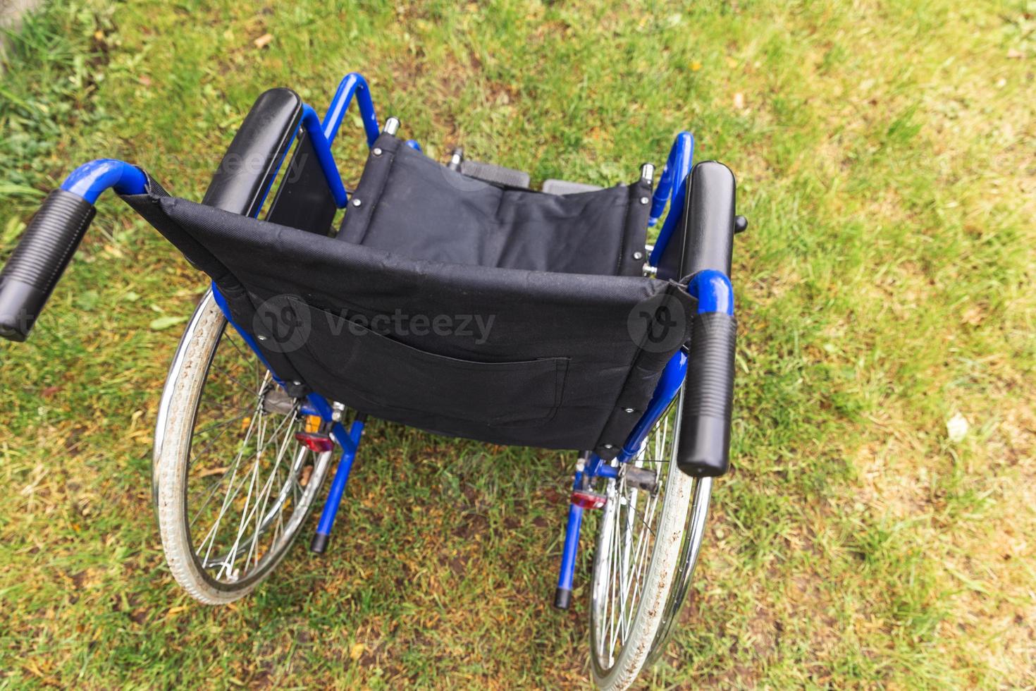 sedia a rotelle vuota in piedi nel parco dell'ospedale in attesa di servizi per i pazienti. sedia a rotelle per persone con disabilità parcheggiate all'aperto. accessibile a persone con disabilità. concetto medico sanitario. foto