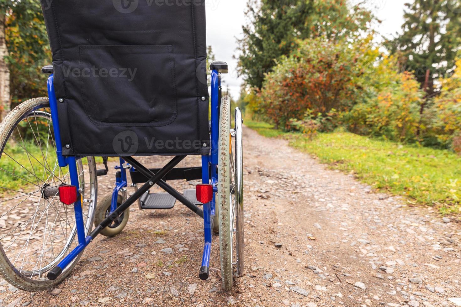 sedia a rotelle vuota in piedi sulla strada in attesa di servizi per i pazienti. sedia a rotelle per persone con disabilità parcheggiate all'aperto. accessibile a persone con disabilità. concetto medico sanitario. foto