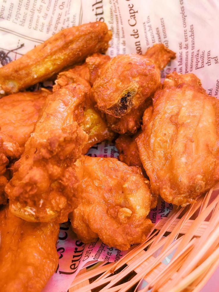 delizioso fritte pollo Ali nel un' cestino a un' ristorante foto