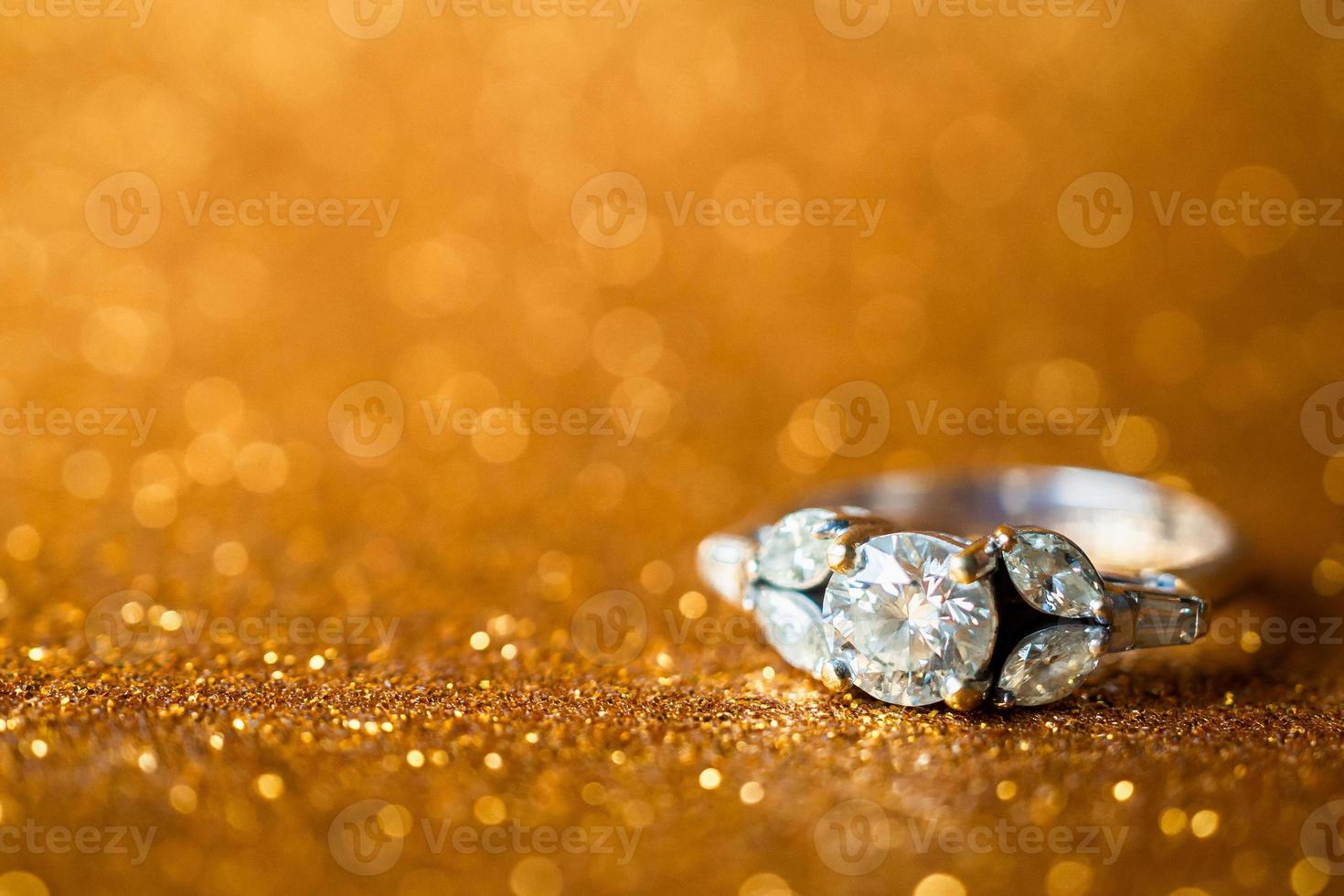 gioielli anello di diamanti con astratto festivo glitter vacanze di natale texture sfocatura dello sfondo con luce bokeh foto