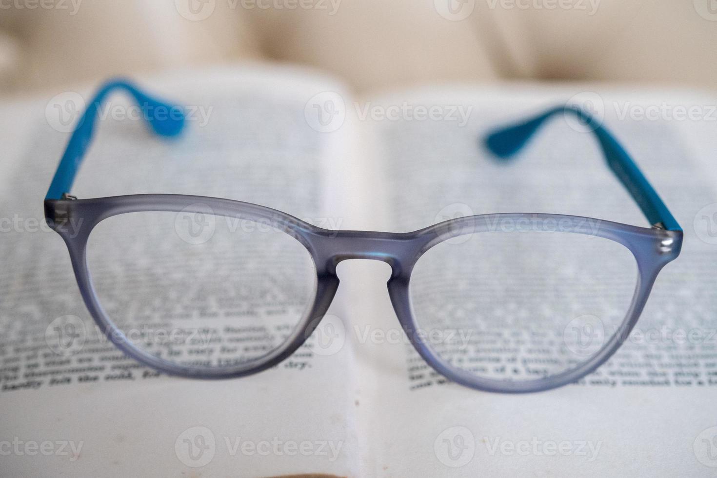 leggero blu lettura bicchieri isolato su un' libro foto