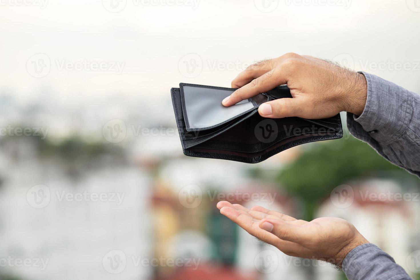 un vuoto portafoglio nel il mani di un' giovane uomo foto