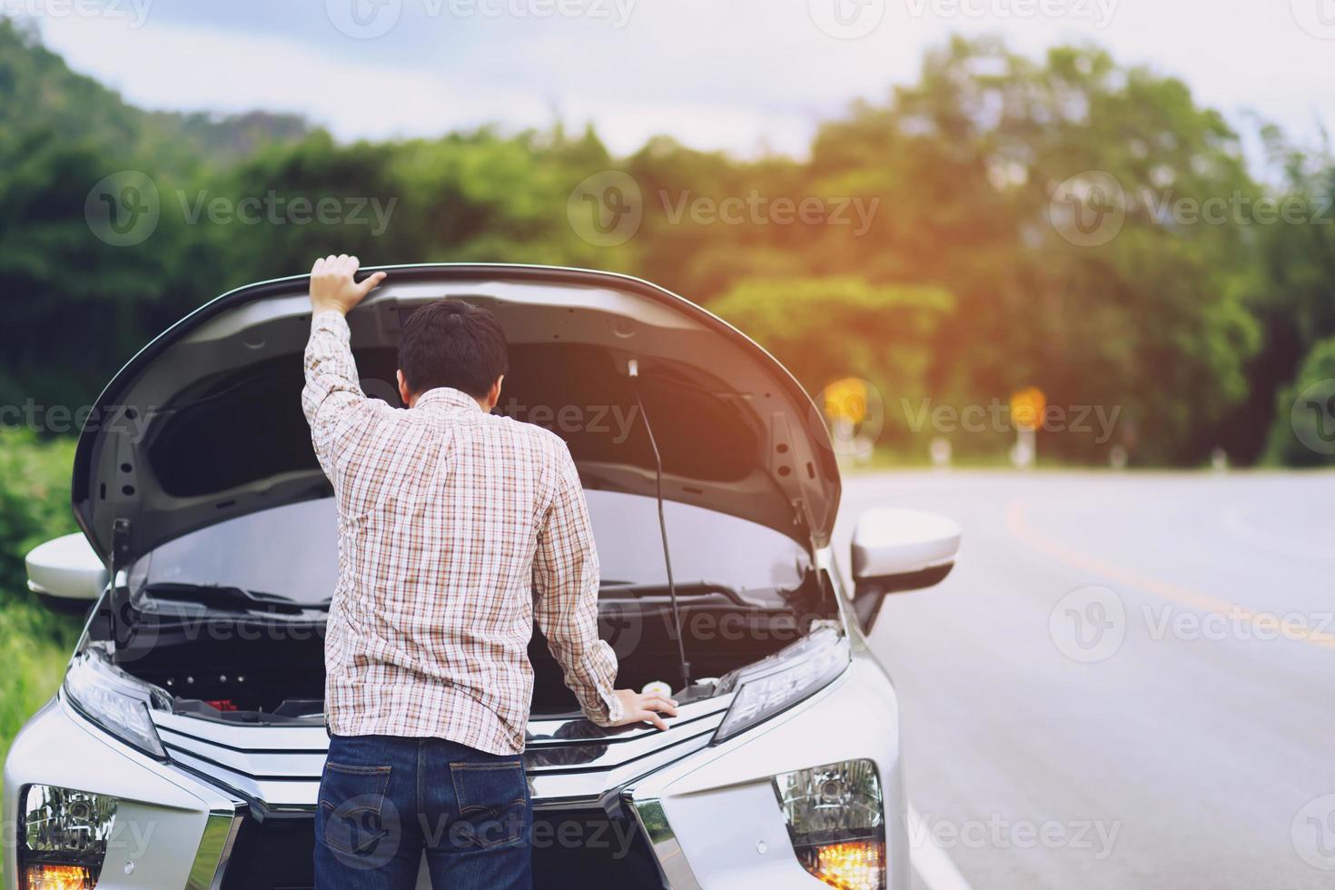 giovane uomo stressato che ha problemi con il suo stress rotto nella sala macchine dell'auto incidente al motore guasto in attesa di aiuto. foto