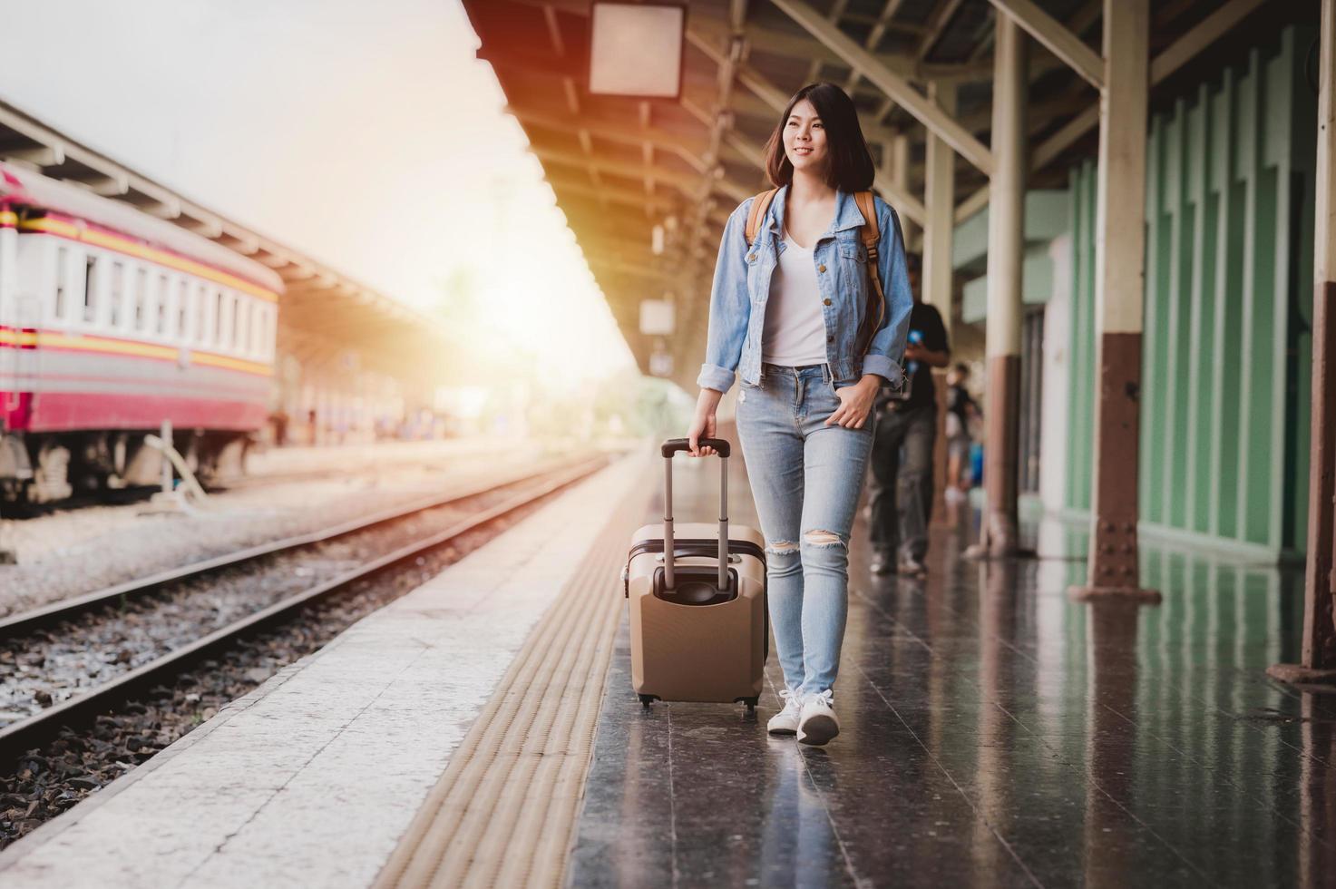 donna con i bagagli alla stazione ferroviaria foto