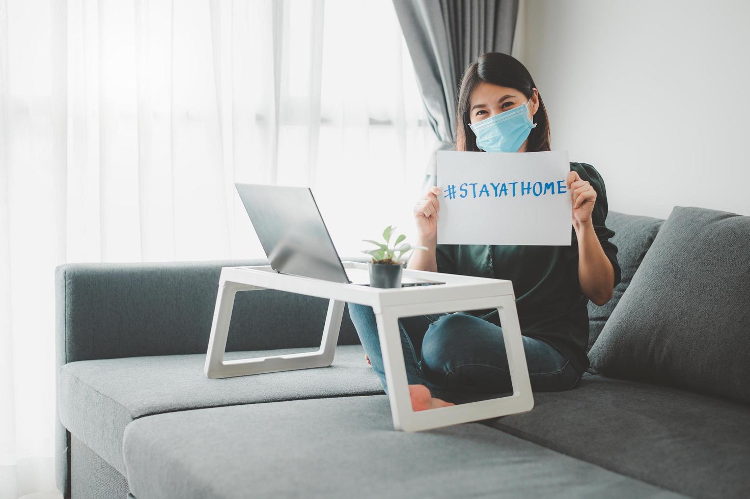 donna che indossa la maschera che lavora a casa foto