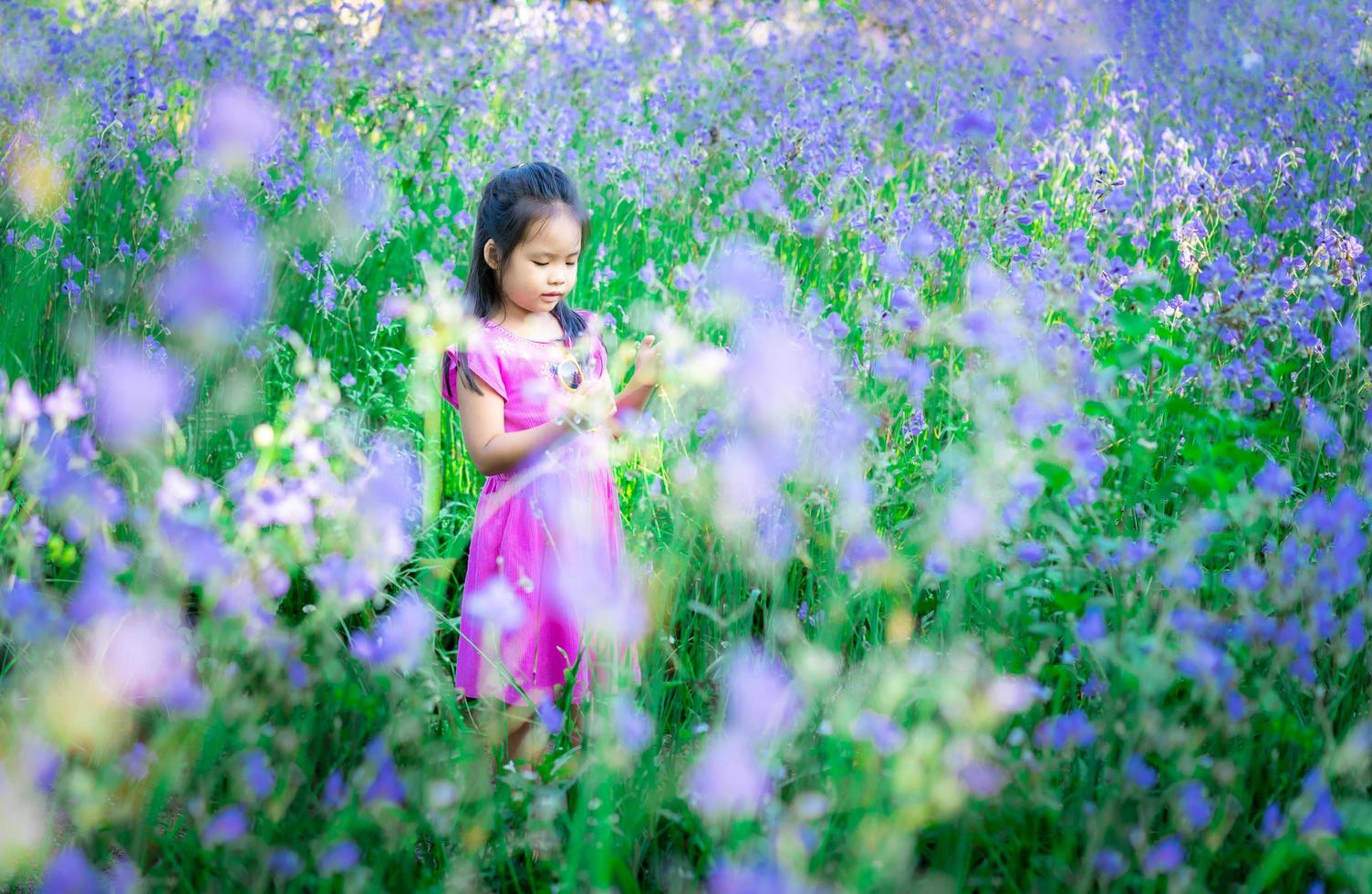 piccola ragazza asiatica felice in giardino floreale foto