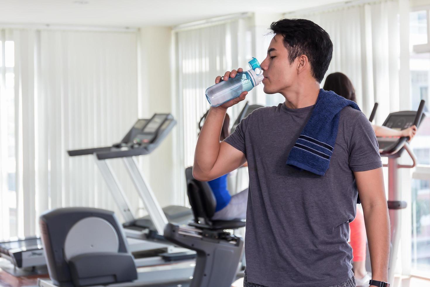 uomo acqua potabile in palestra foto