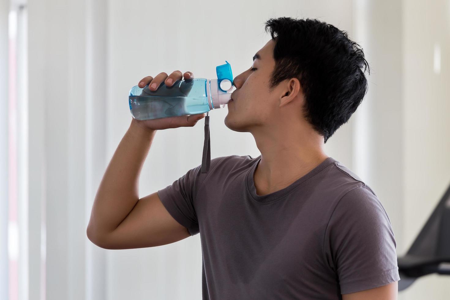 uomo acqua potabile in palestra foto