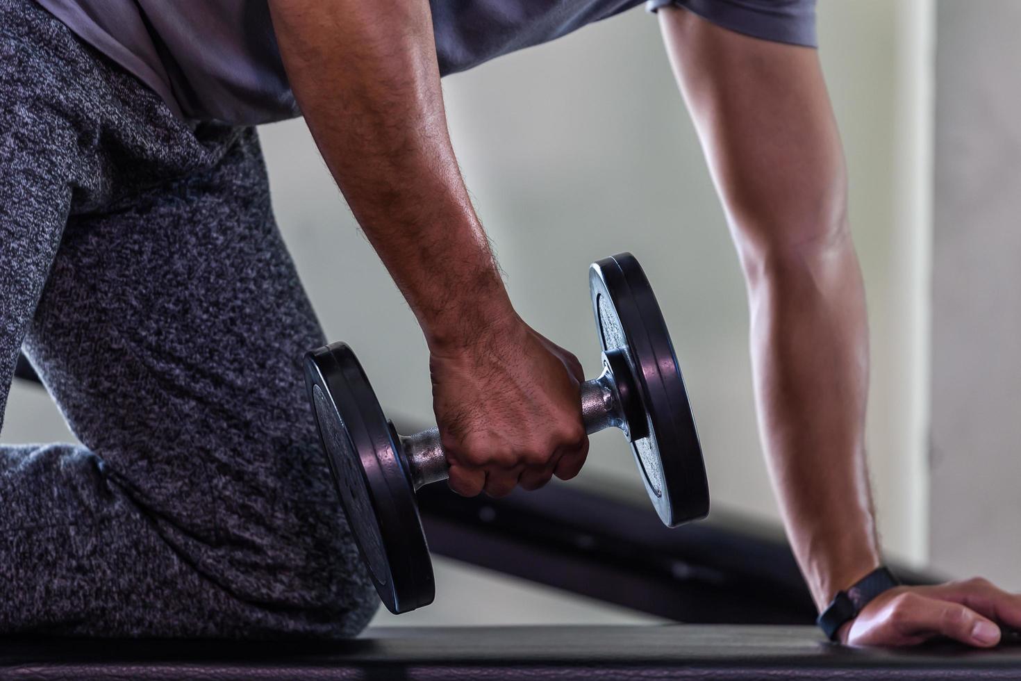 uomo con manubri in palestra foto