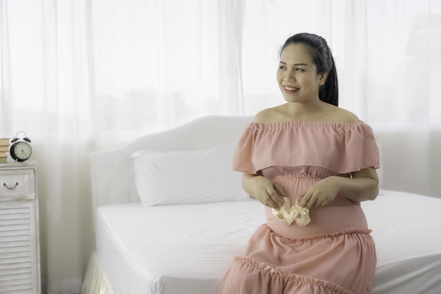 donna incinta asiatica in abito foto