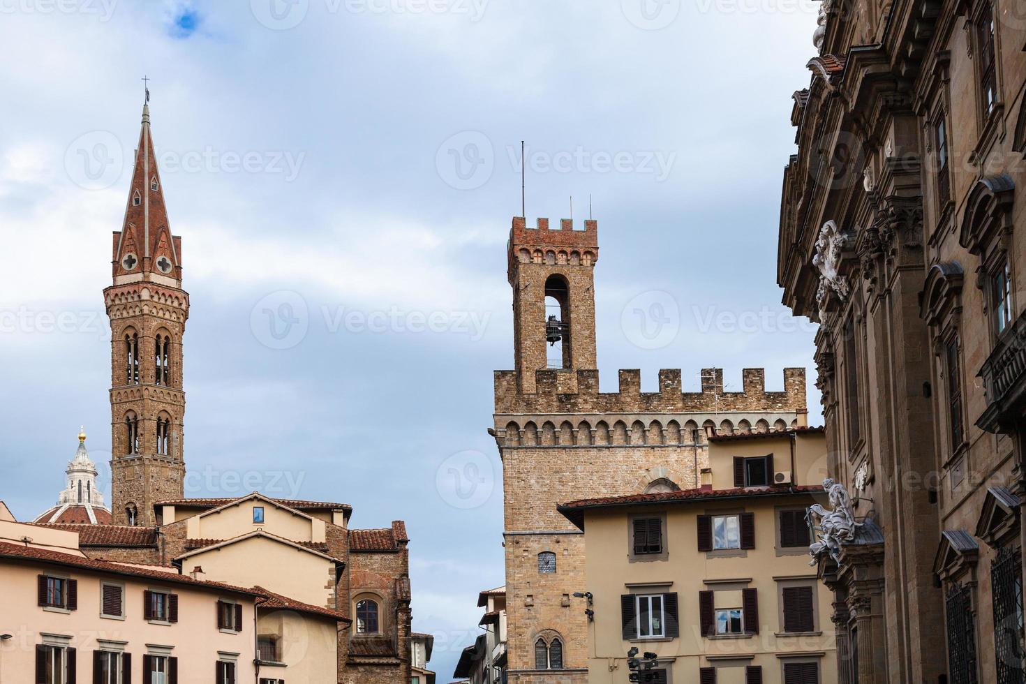 torri badia fiorentina e bargello al di sopra di case foto