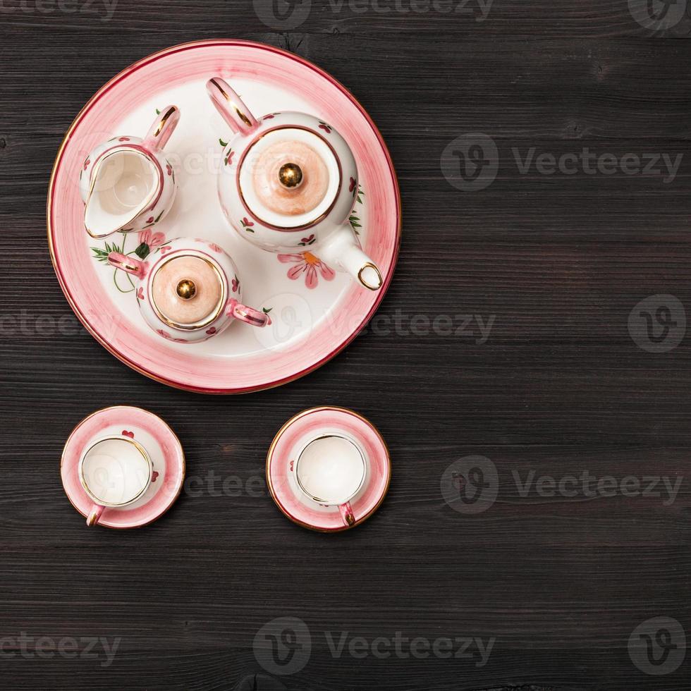 superiore Visualizza di rosa tè impostato su buio Marrone tavola foto