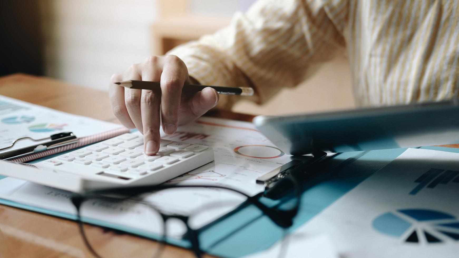 contabilità della donna facendo uso di calcolo e lavoro con il computer portatile sull'ufficio dello scrittorio, concetto di finanza foto