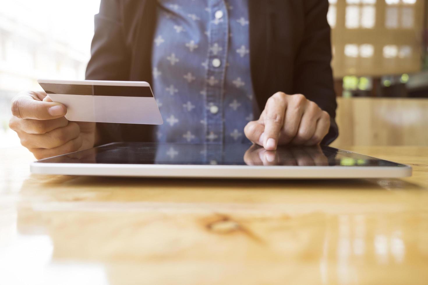 una donna si siede alla scrivania per fare shopping online foto