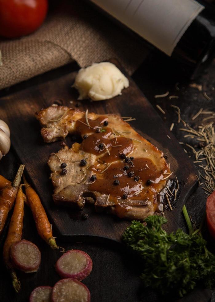 bistecca alla griglia barbecue di maiale sul tagliere foto