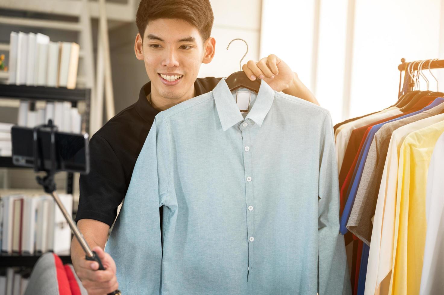 l'uomo sta prendendo selfie con la camicia in mano foto