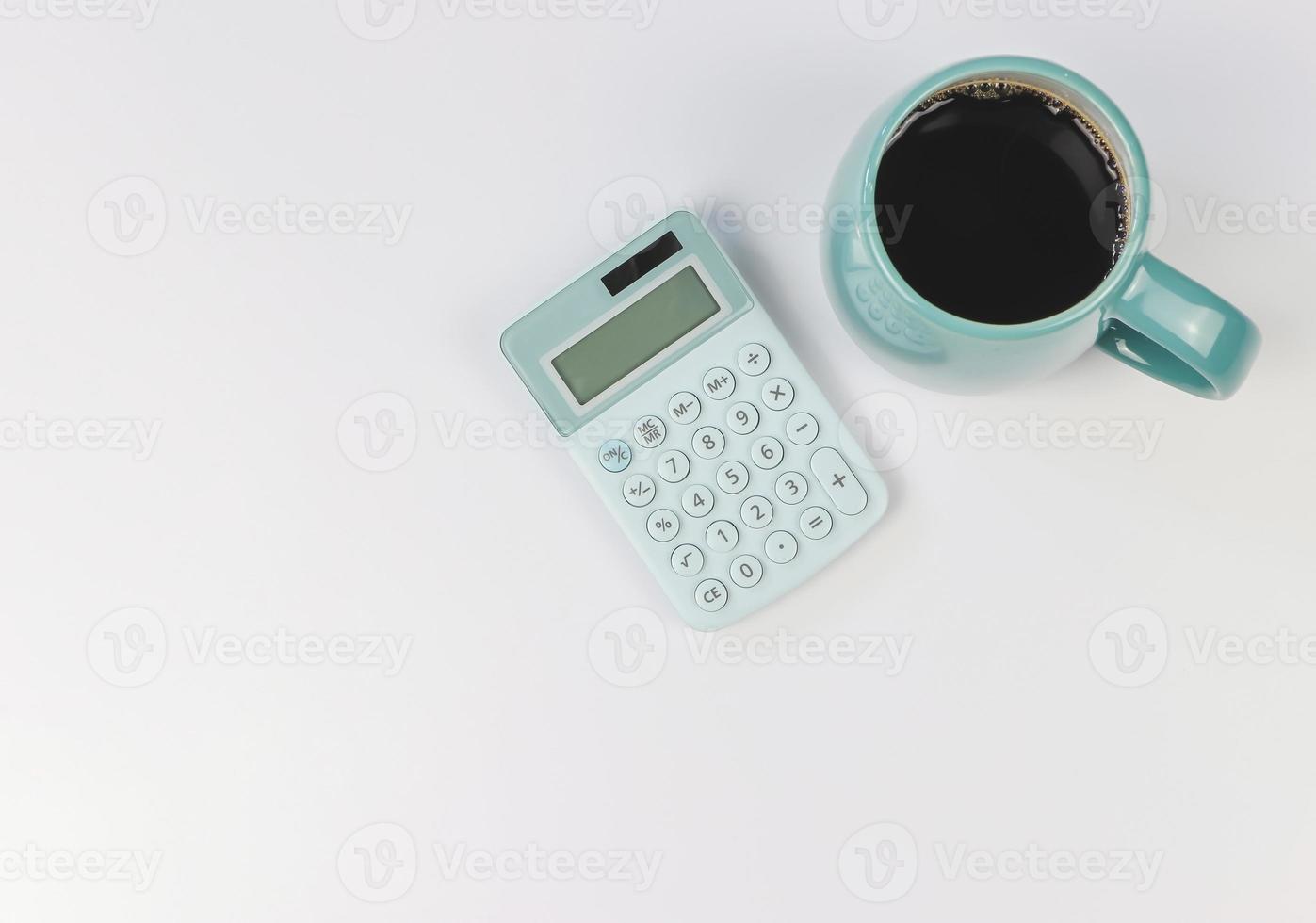 piatto posare di blu calcolatrice e blu tazza di nero caffè su bianca sfondo con copia spazio. foto