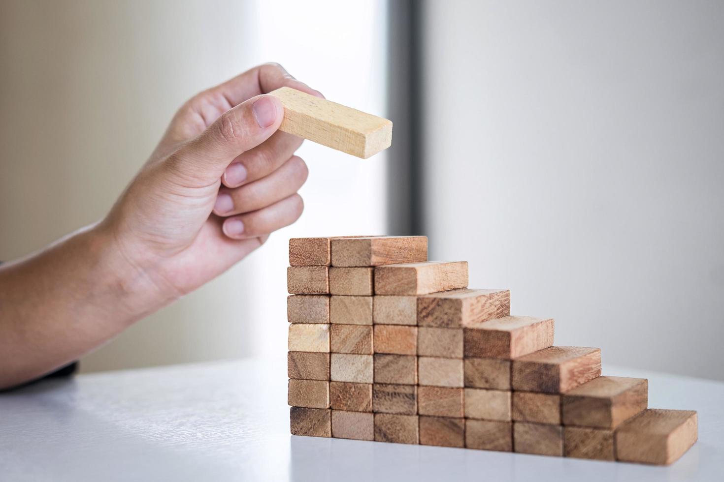 mano che impila i blocchi di legno foto