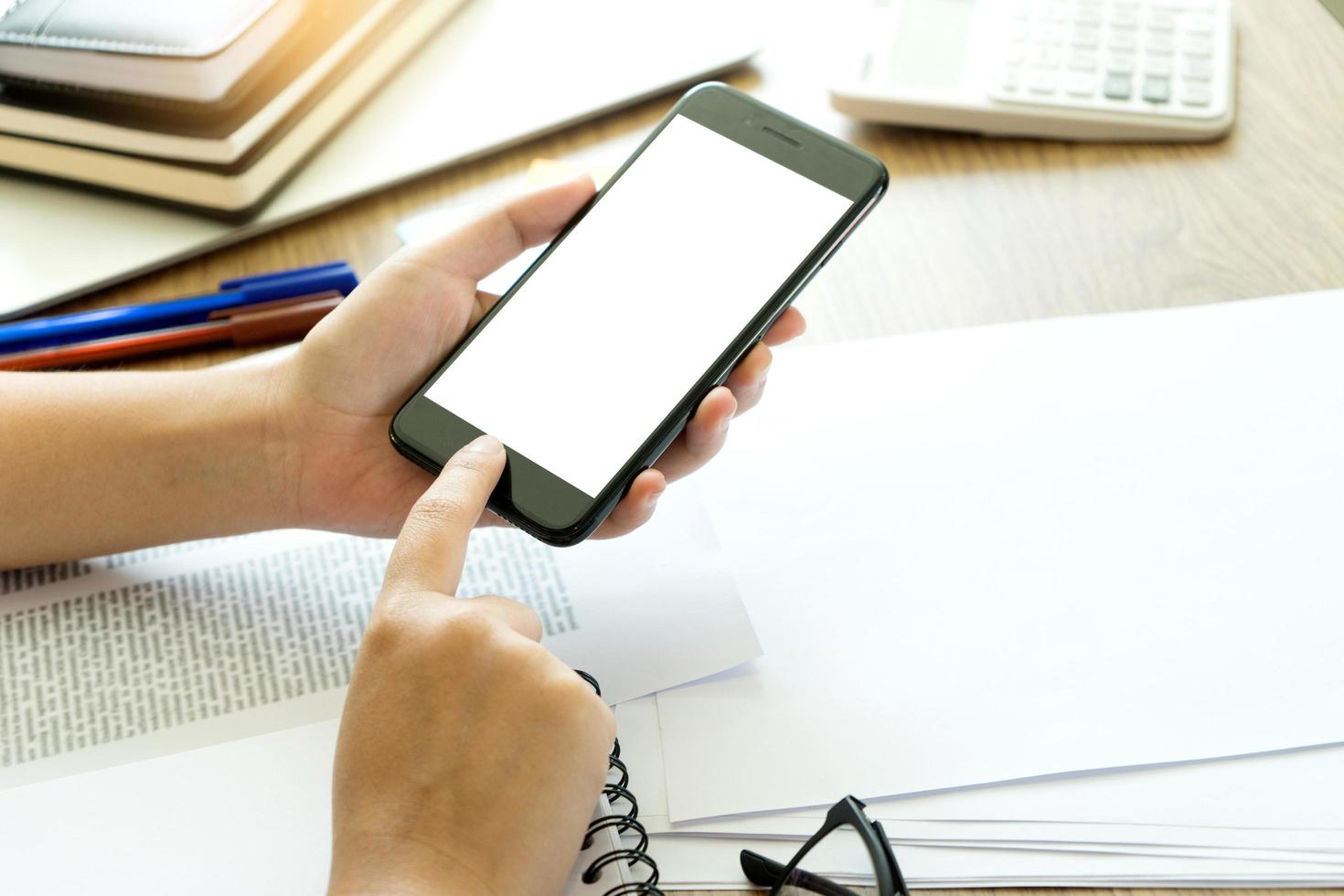 colpo del primo piano delle mani del lavoratore utilizzando il telefono foto