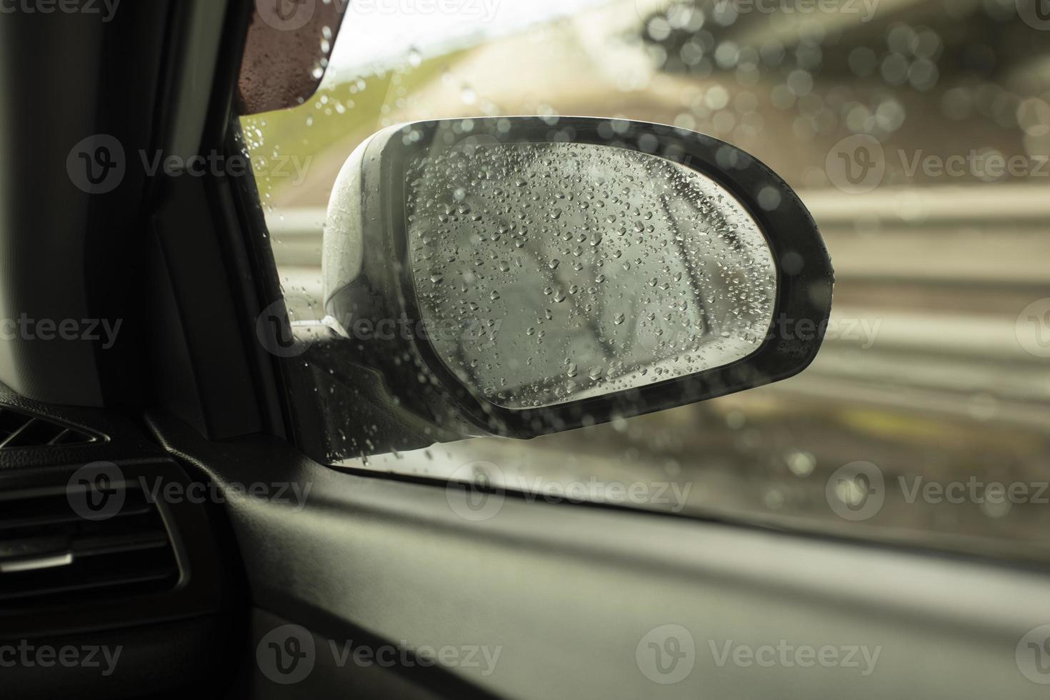 retrovisore specchio di auto dietro a bagnato bicchiere. Visualizza di strada nel pioggia. dettagli di viaggio. foto