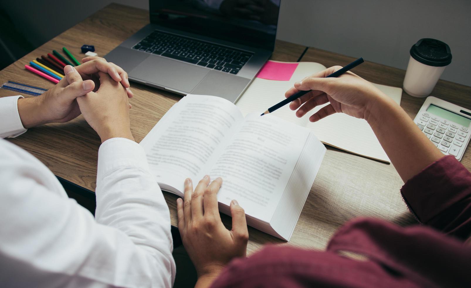 studenti che leggono un libro alla scrivania foto