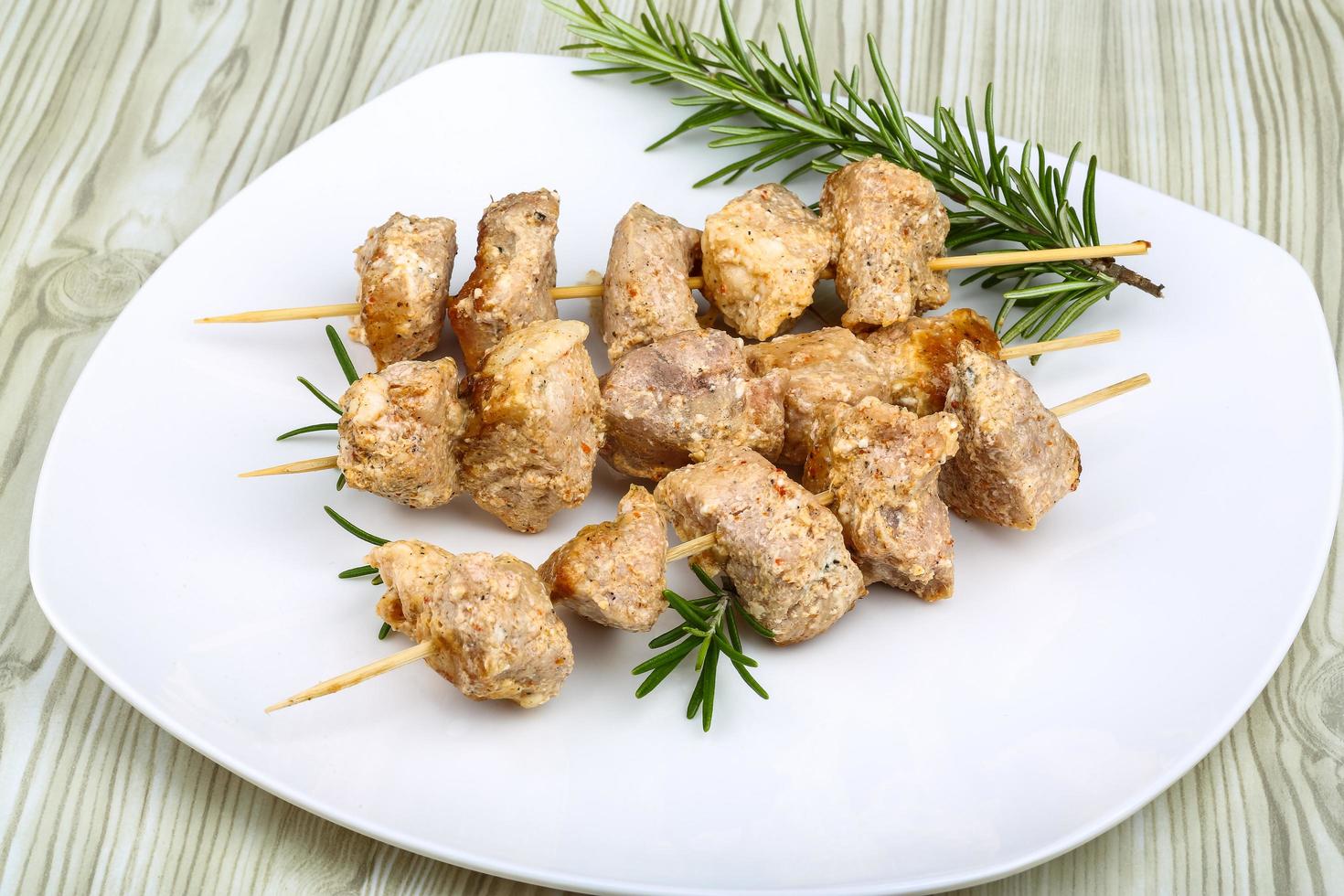 pollo spiedini su il piatto e di legno sfondo foto