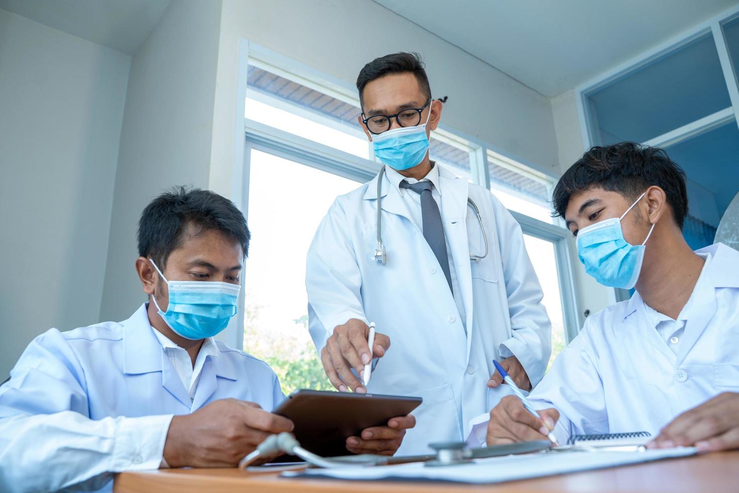 uomini con camici da laboratorio e maschere per il viso foto