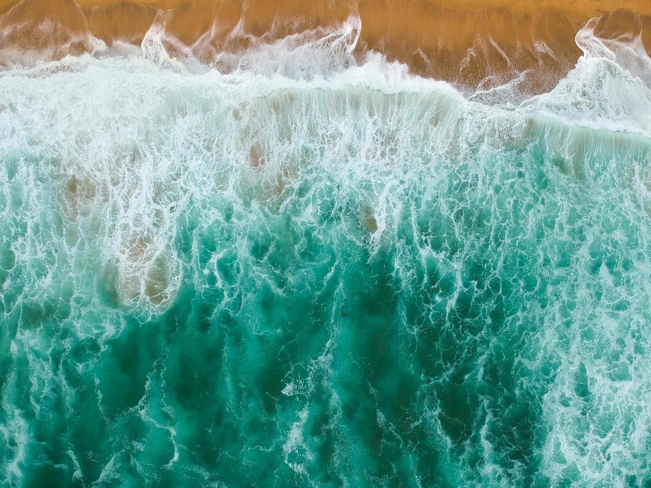 le onde si infrangono sulla riva foto