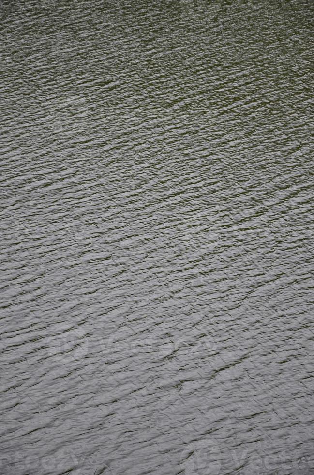 il struttura di buio fiume acqua sotto il influenza di vento, impresso nel prospettiva. verticale Immagine foto