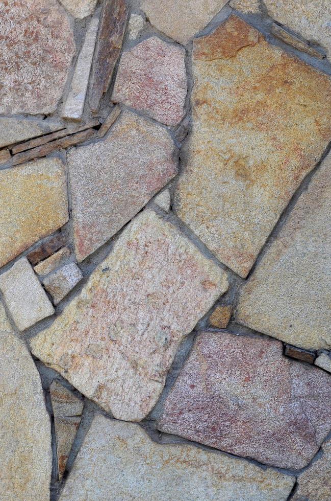 il struttura di un' forte pietra parete di molti concretizzato pietre di vario forme foto