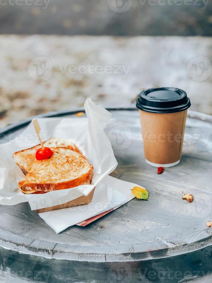 mettilo a posto. Sandwich su carta con caffè. strada cibo concetto foto