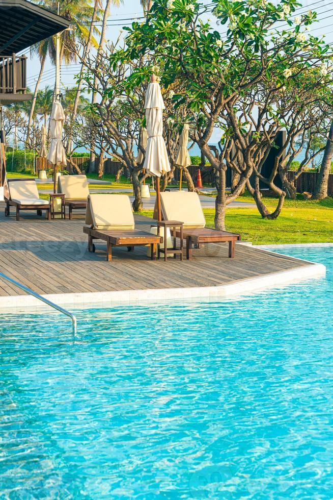 ombrellone con lettino piscina intorno alla piscina con sfondo oceano mare foto