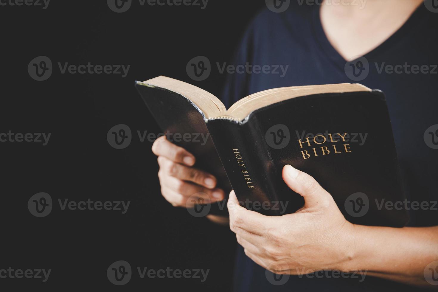 giovane donna persona mano Tenere santo Bibbia con studia a casa. adulto femmina cristiano lettura libro nel Chiesa. ragazza apprendimento religione spiritualità con pregare per Dio. concetto di alunno formazione scolastica fede. foto