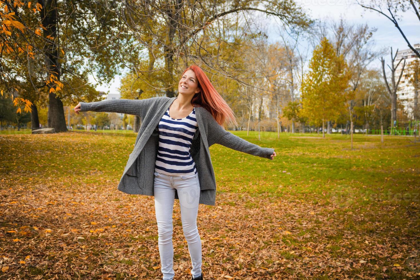 bellissimo donna godendo nel autunno con parco con braccia proteso. foto