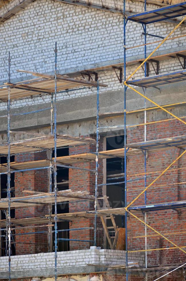 impalcature installato vicino il multipiano mattone edificio sotto costruzione foto