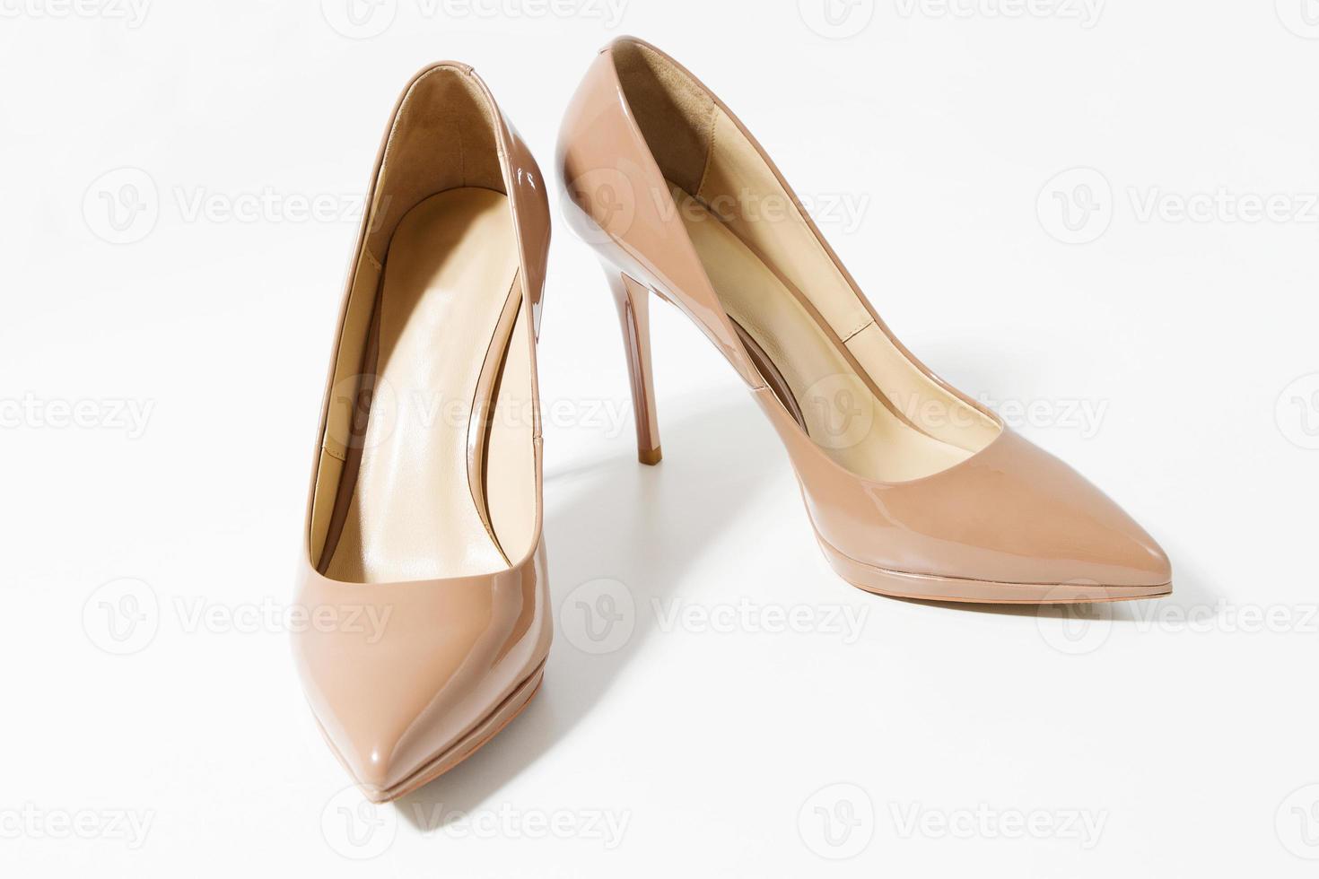 vicino su scarpa donne. beige brevetto femmina pelle scarpe isolato su bianca sfondo. donna alto tacchi calzature su pavimento. moda e shopping concetto. superiore Visualizza. copia spazio. selettivo messa a fuoco. foto