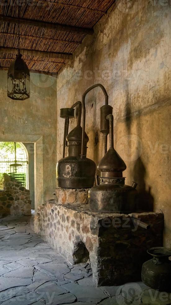 avvicinamento di un autentico antico rame casa distillatore, nel vecchio costruzione, su calcolo, patina su muri e soffitto foto