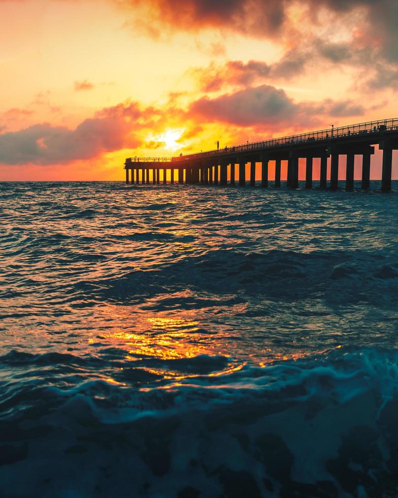 onde del mare che si infrangono a terra durante il tramonto foto