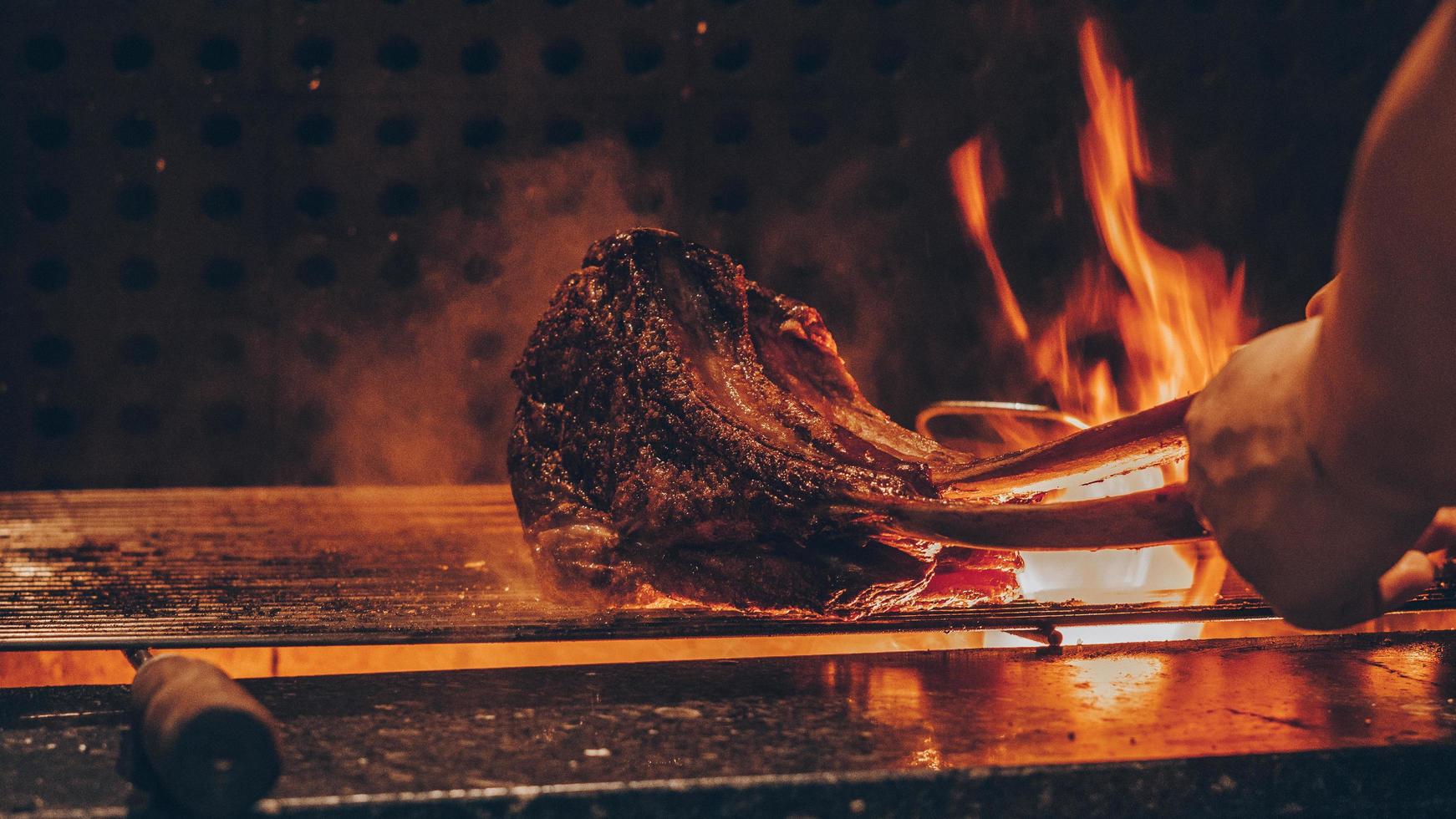 persona che griglia carne foto