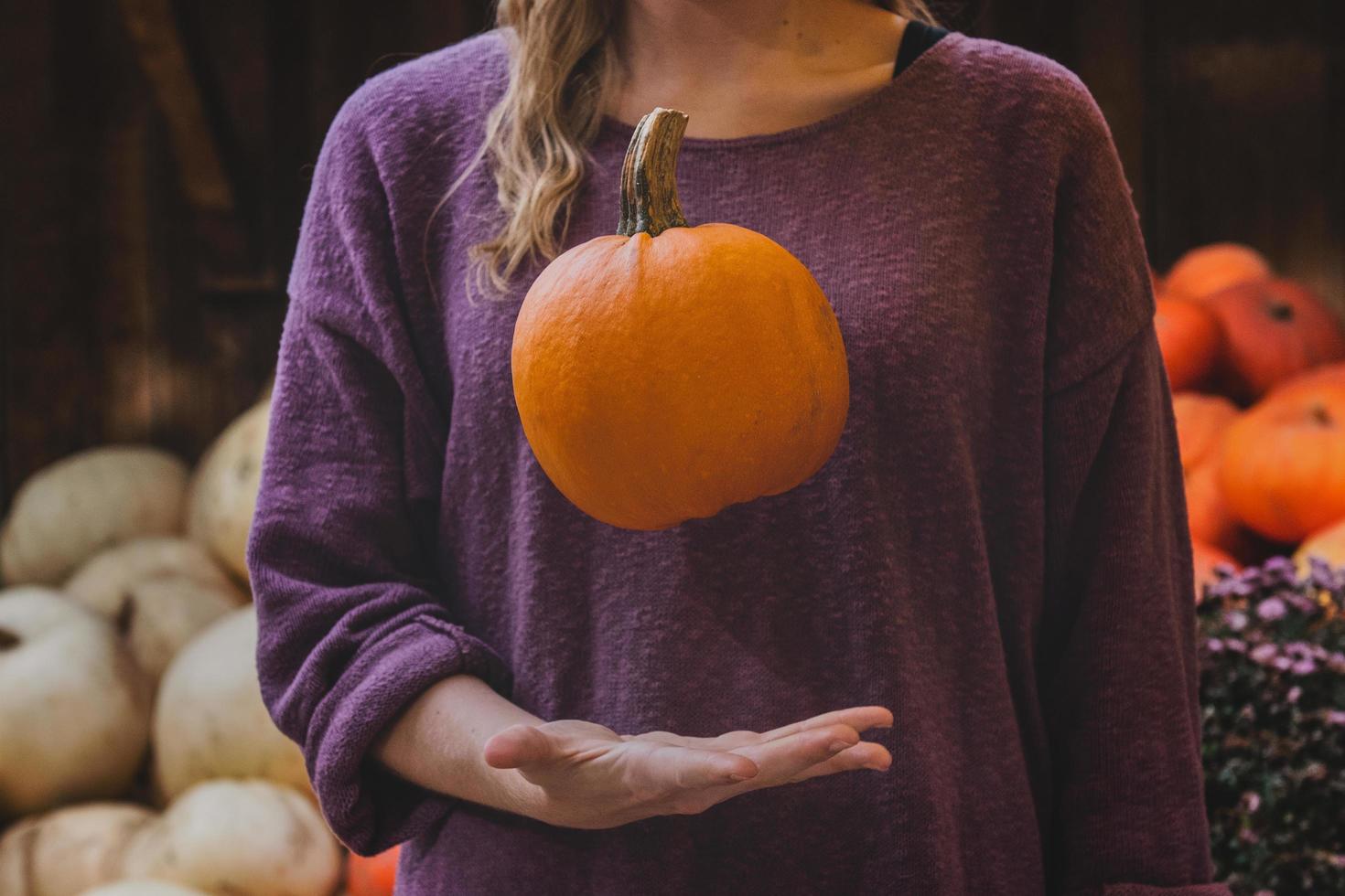 donna che cattura zucca arancione foto