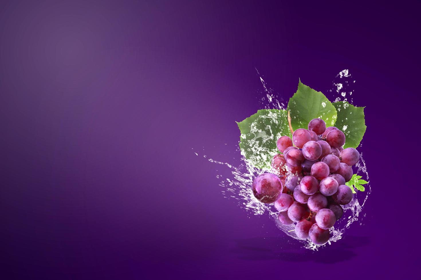spruzzi d'acqua sulle uve rosse fresche foto