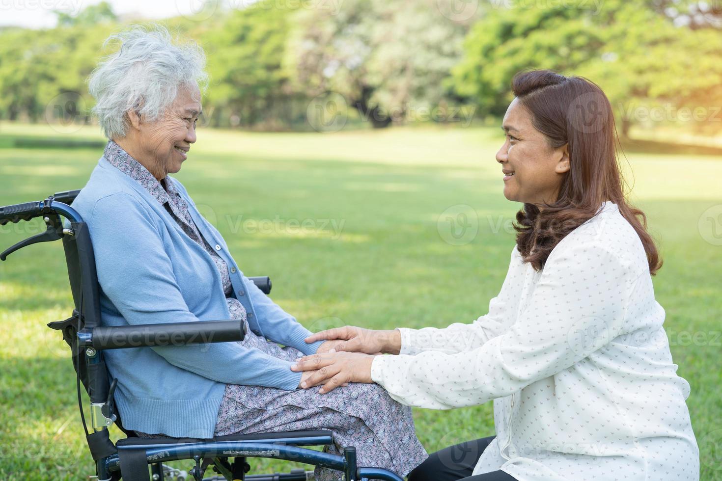 assistenza e cura del caregiver paziente asiatico anziano o anziano della donna che si siede sulla sedia a rotelle nel parco, concetto medico forte sano. foto